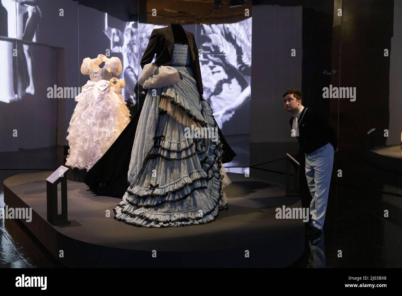 V & A Ausstellung Maskulinitäten gestalten:The Art of Menswear, ein Mann, der sich das Kleid von Harry Styles ansah, das von Alessandro Michele für Gucci entworfen wurde. Stockfoto