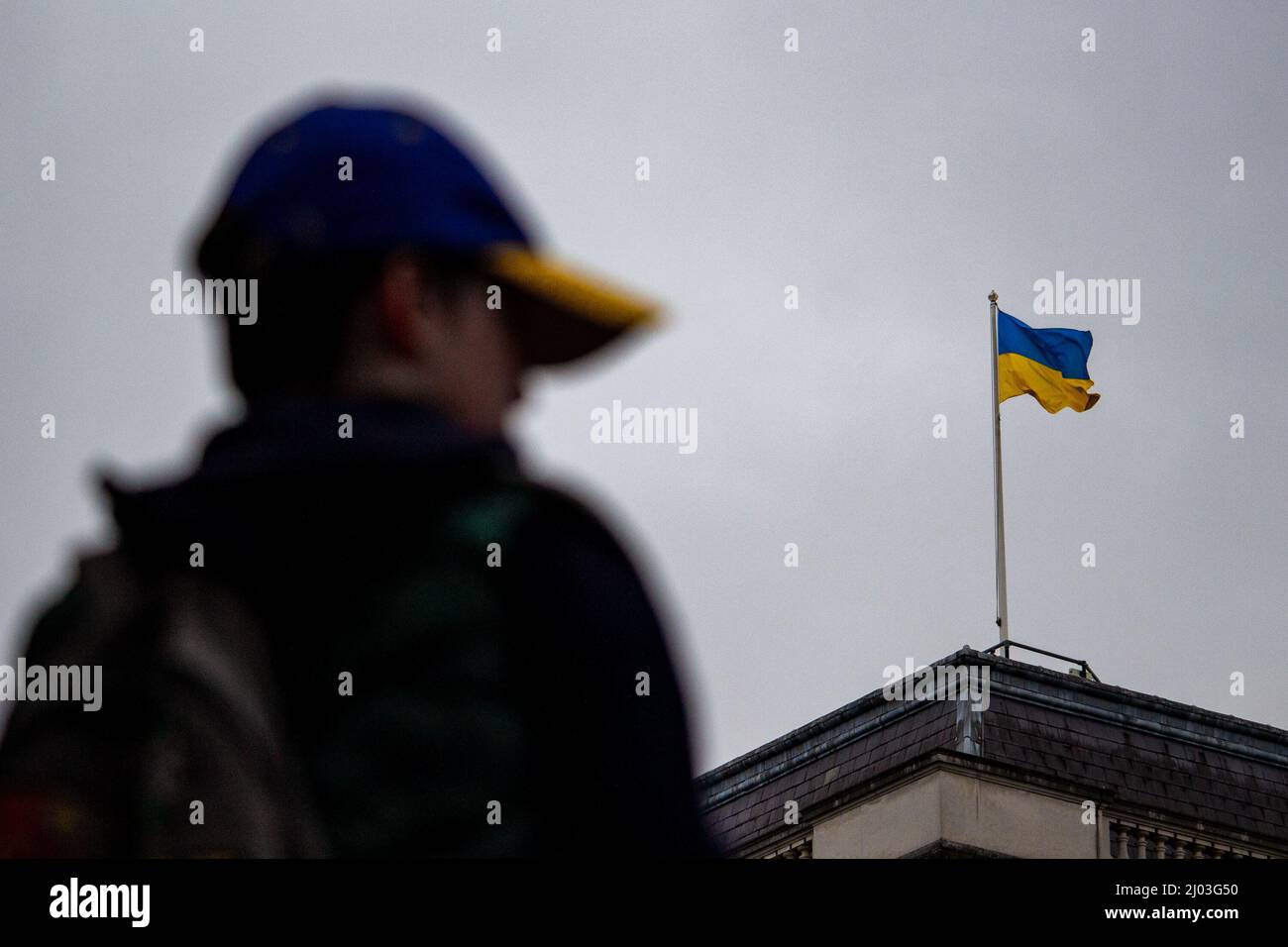 Ein Junge mit Baseballmütze in ukrainischen Farben, gesehen mit der ukrainischen Flagge, die während proukrainischer Proteste über der Downing Street flog, März 2022 Stockfoto