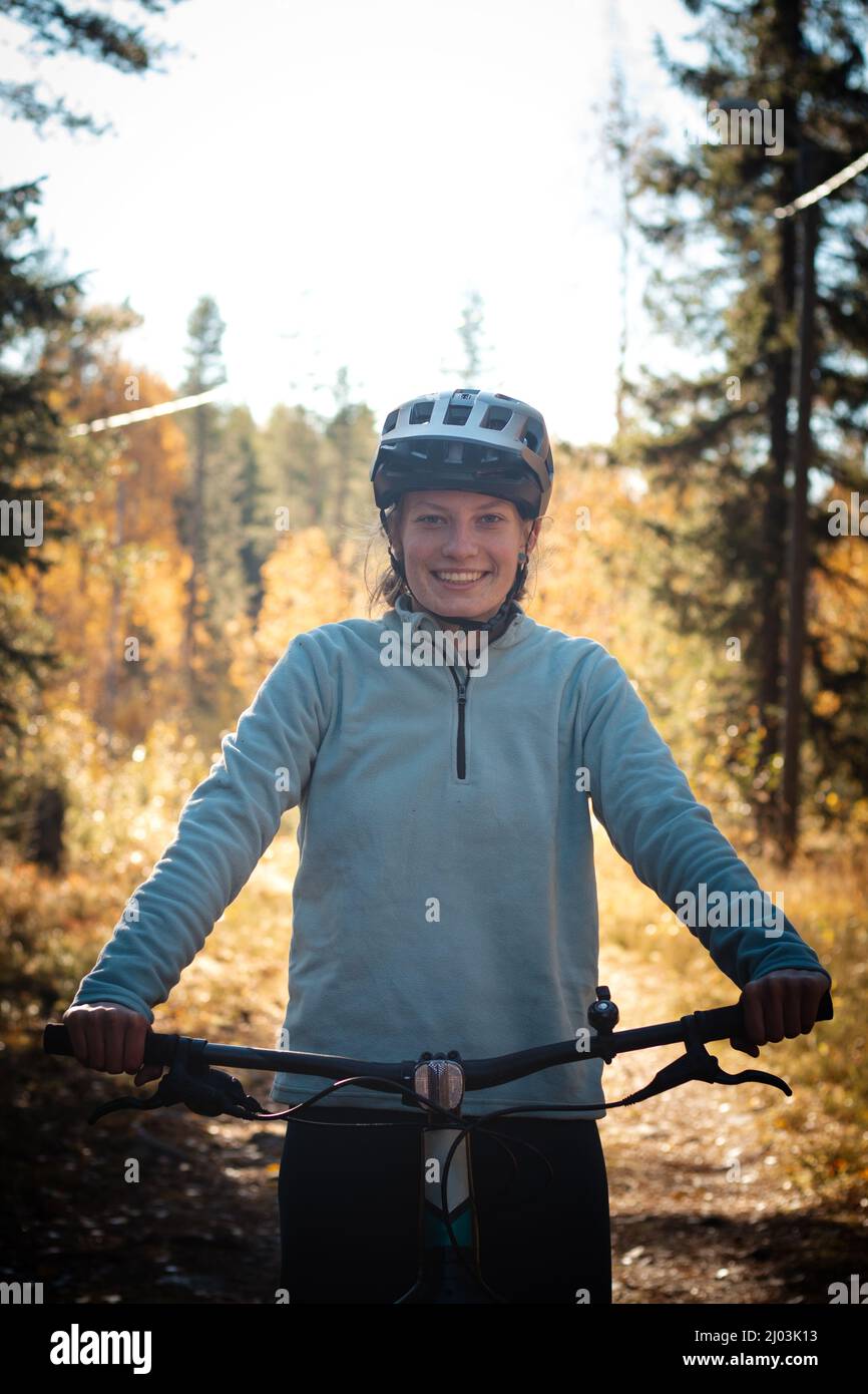 Junge sympathische Dame mit einem schönen realistischen Lächeln, während sie sportlich ist. Radfahrer, die in der wilden Natur Finnlands auf dem Fat Bike reiten. Vuokatti. Stockfoto