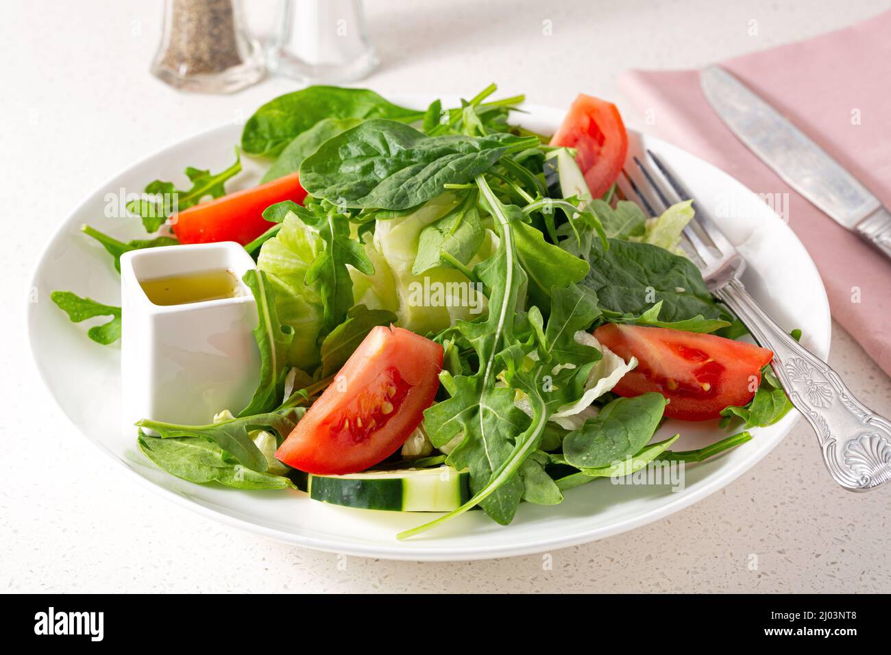 Frischer grüner Sommergarten-Salat mit Tomaten und Dressing Stockfoto