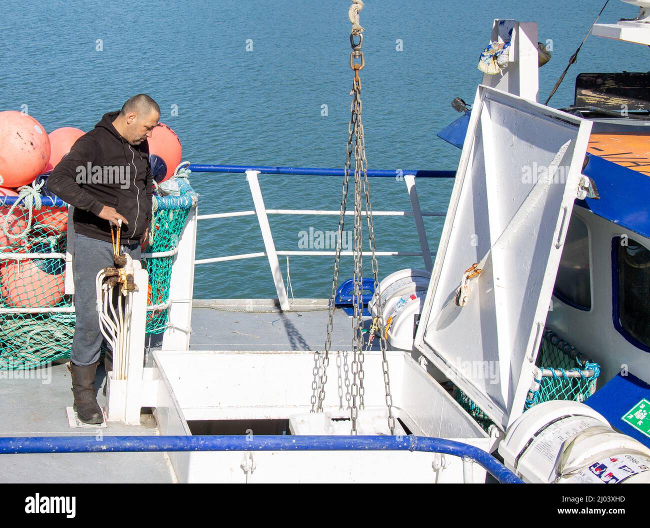Fischer entladen Kisten mit Fischen aus Fischtrawler Fisch halten. Stockfoto