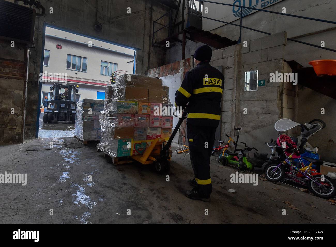 Ostrava, Tschechische Republik. 16. März 2022. Dutzende von Paletten humanitärer Hilfe wurden am 16. März 2022 von Feuerwehrleuten in einem Sammelzentrum in Ostrava, Tschechien, verladen. Über das Tschechische Rote Kreuz wird ein großer Teil dieser materiellen Hilfe direkt an Bedürftige in die Ukraine gehen und ein Teil wird für Flüchtlinge verwendet werden, die in die Tschechische Republik gegangen sind. Kredit: Jaroslav Ozana/CTK Foto/Alamy Live Nachrichten Stockfoto