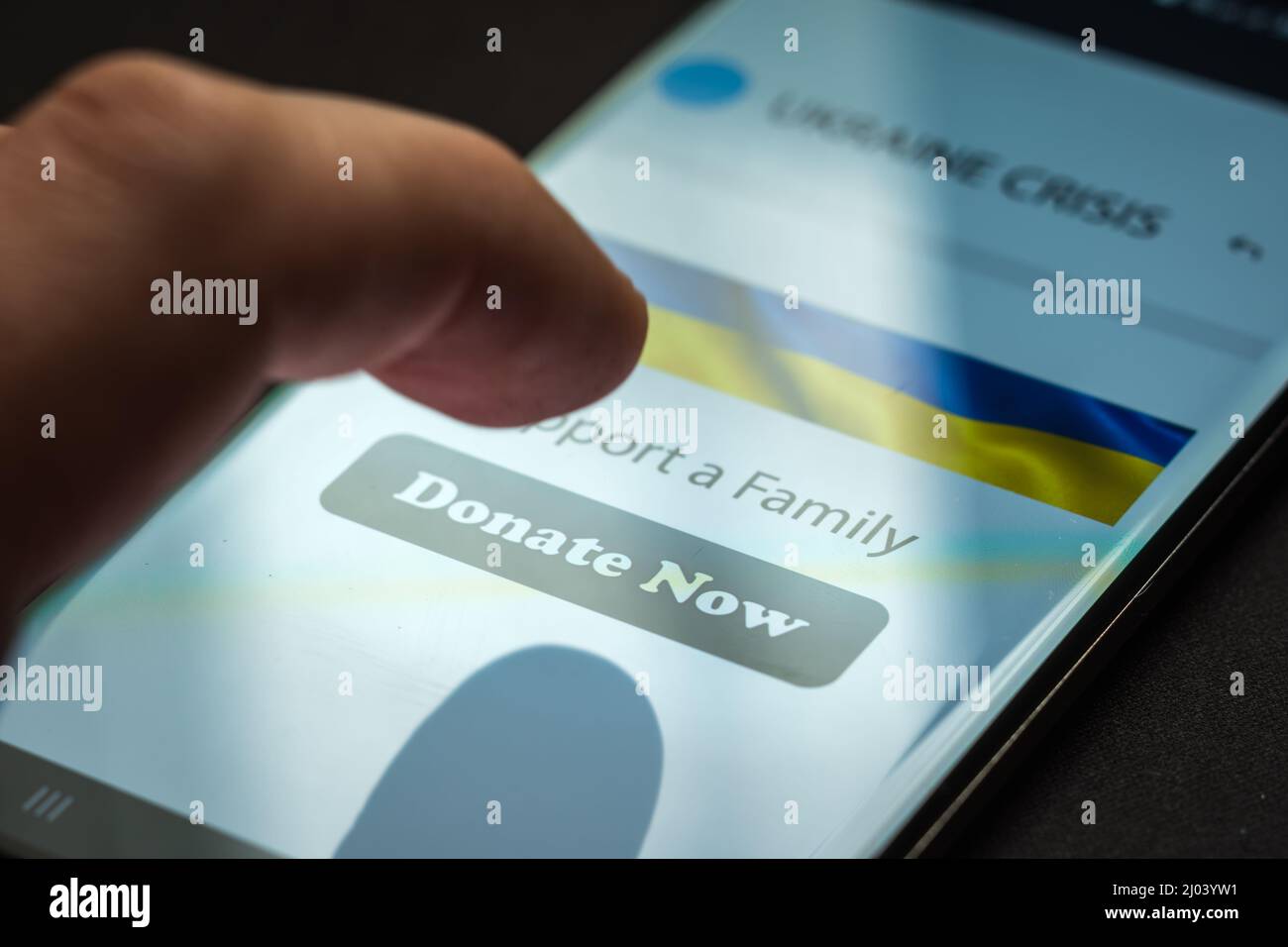 Nahaufnahme durch Drücken der Spendentaste auf dem Smartphone-Bildschirm. Spendengeld Online-Konzept Stockfoto