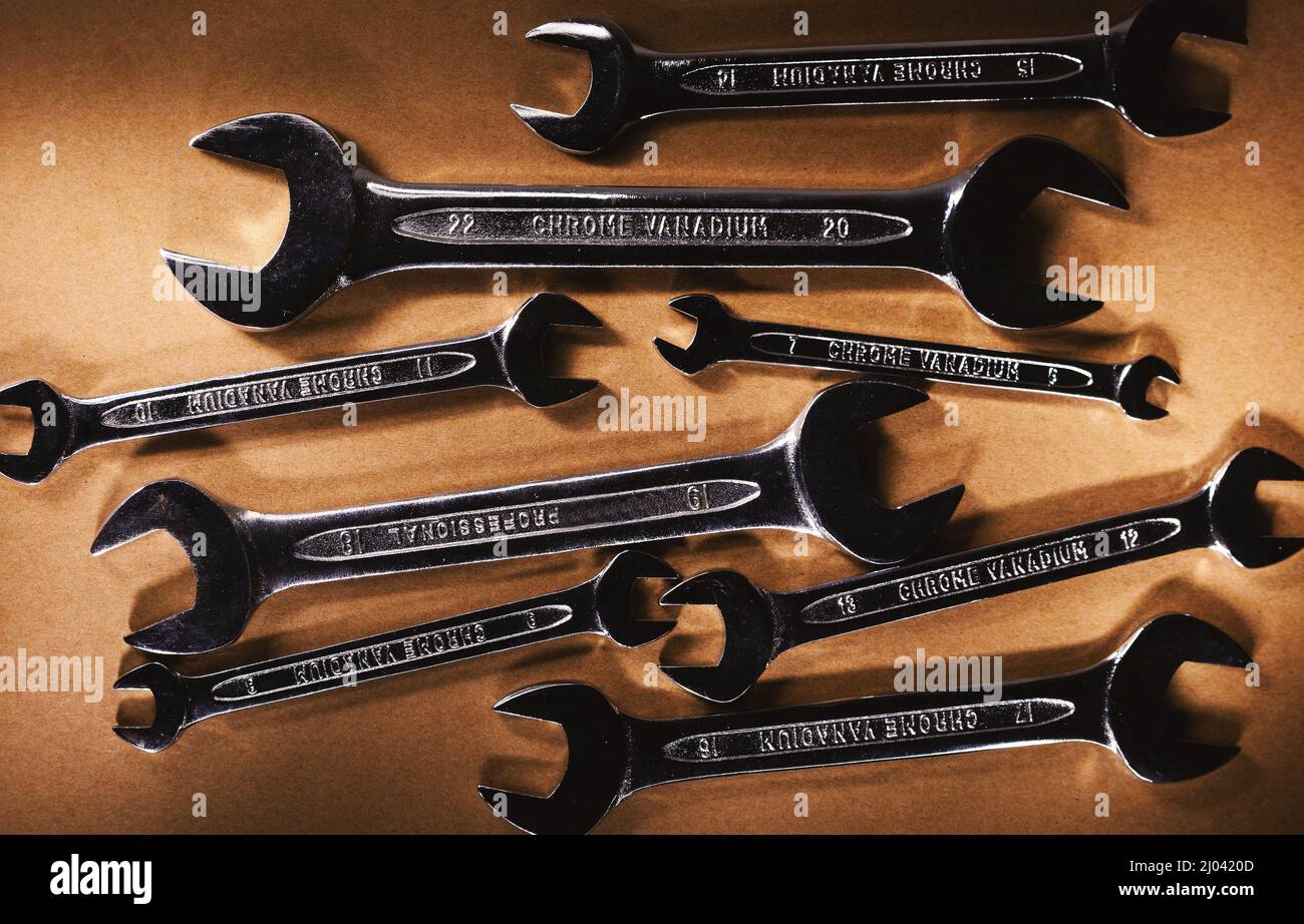 Set aus Stahl-Metallschlüsseln auf braunem Hintergrund. Stockfoto