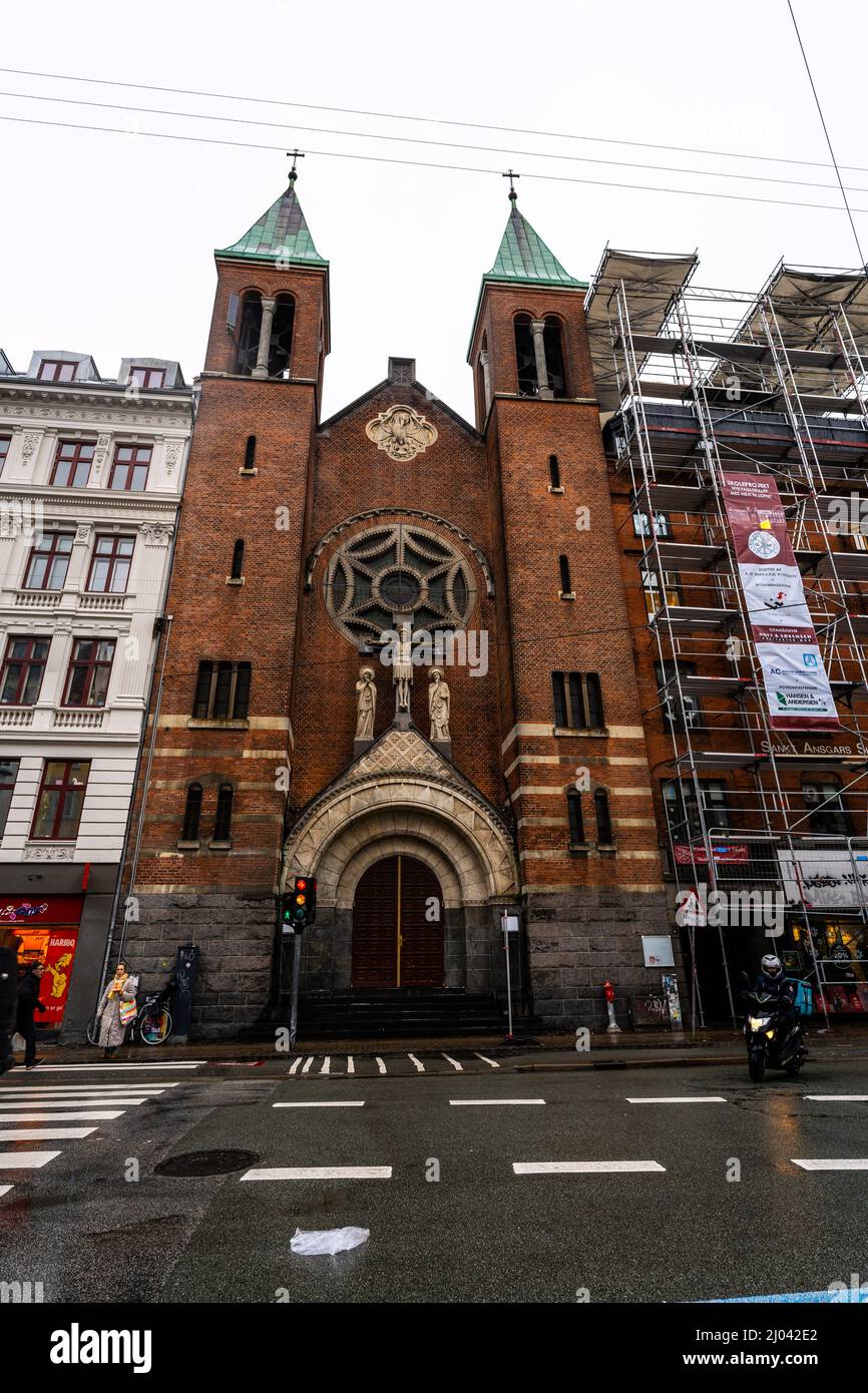 Vertikale Aufnahme von Menschen, die gegen die Herz-Jesu-Kirche in Kopenhagen, Dänemark, laufen Stockfoto