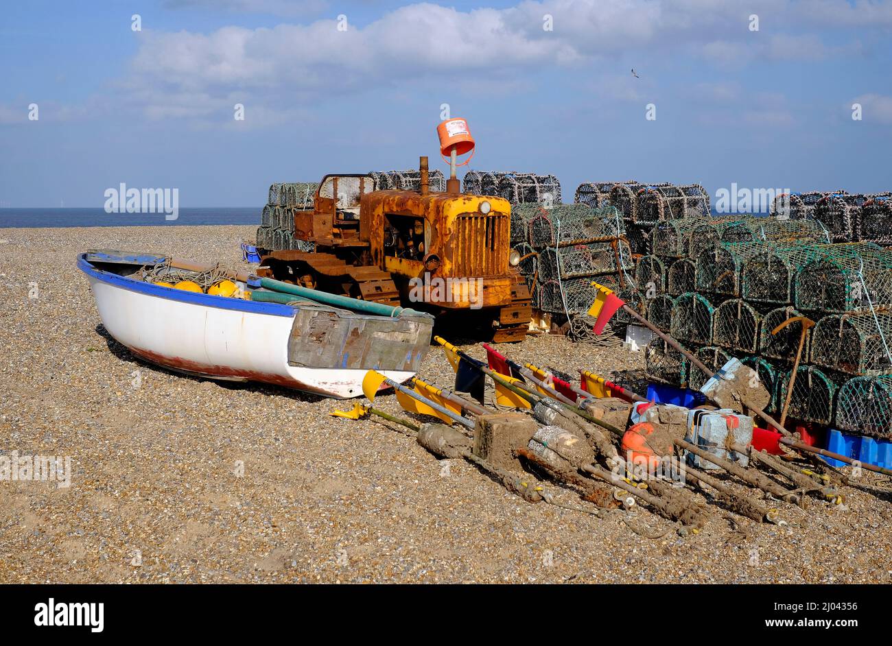 Fischerboot, Traktor und Hummertöpfe am Strand von Cley am Meer, im Norden von norfolk, england Stockfoto