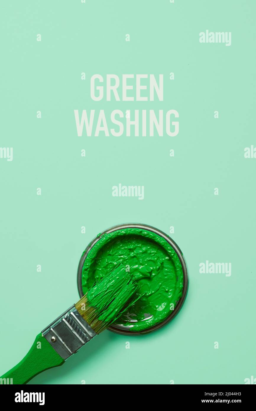 Der Text grünwaschen und ein Pinsel mit grüner Farbe, auf einem hellgrünen Hintergrund Stockfoto