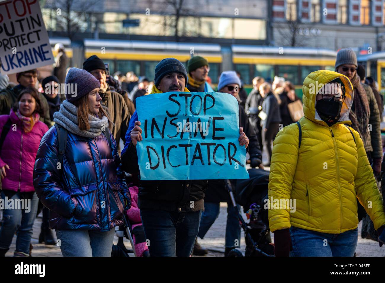 Stoppt den verrückten Diktator. Mann mit blauem Papierbogen gegen den Protest gegen die Invasion der Ukraine in Helsinki, Finnland. Stockfoto