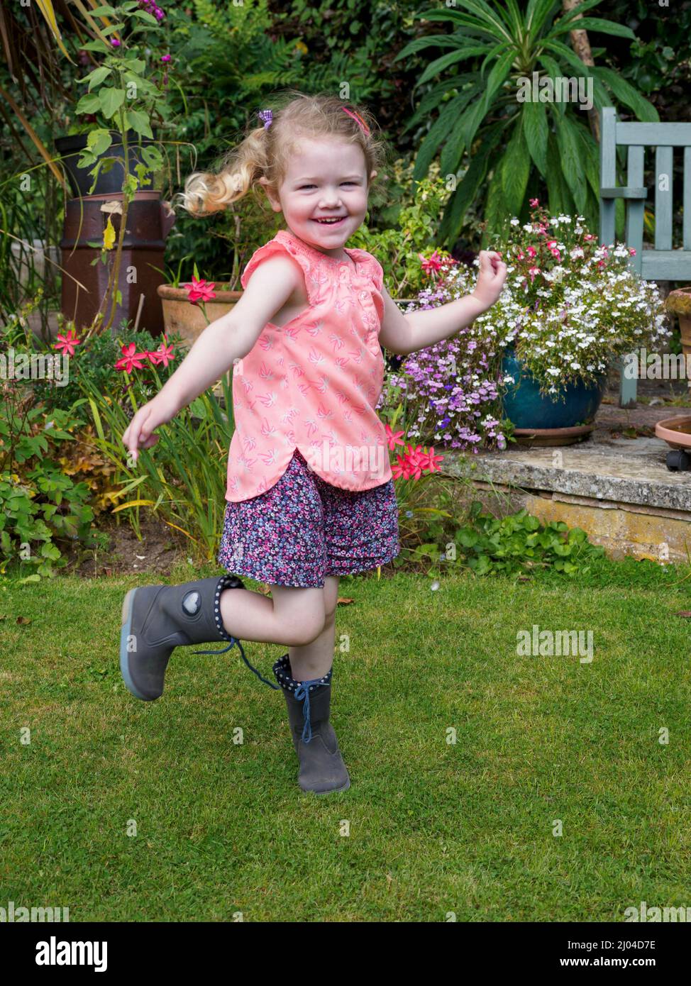 Junges Mädchen, das im Garten tanzt, Großbritannien Stockfoto