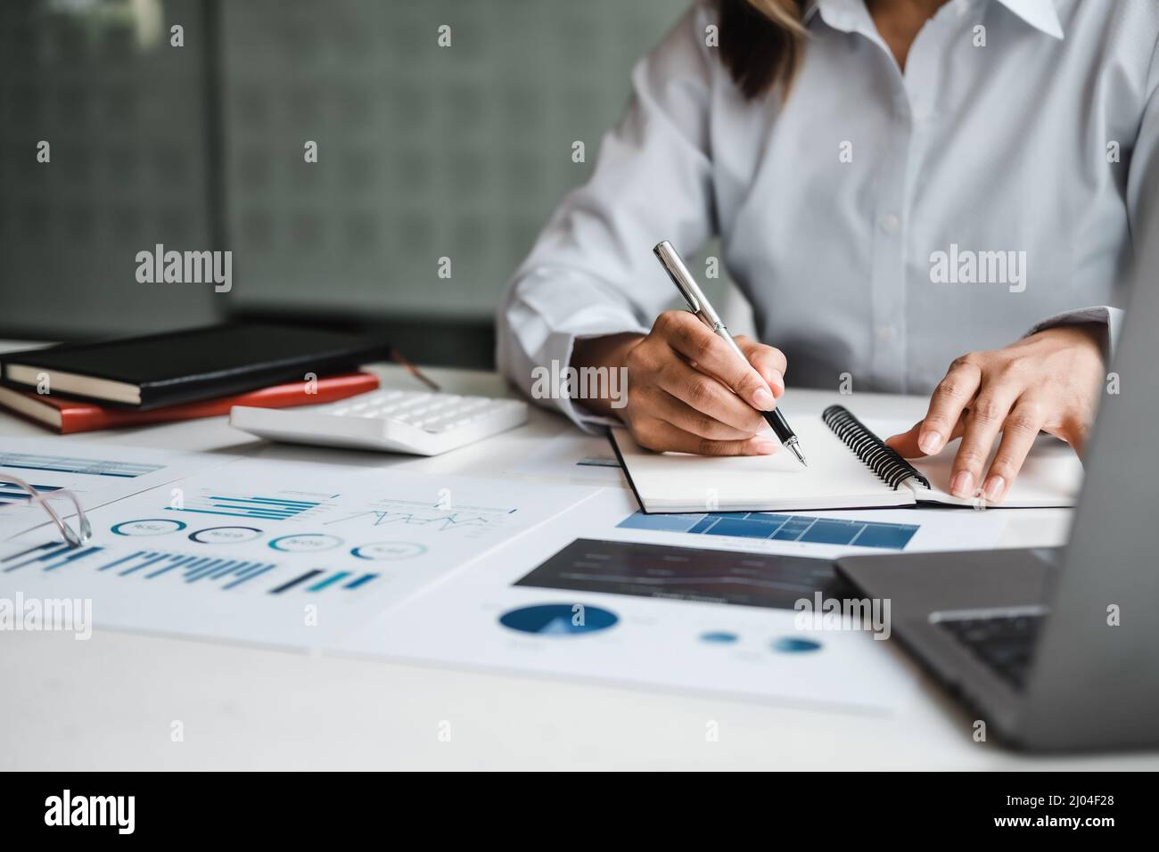 Nahaufnahme Geschäftsfrau, die mit Finanzdaten arbeitet Hand mit Rechner und Schreiben Notiz machen mit rechnen. Finanz- und Rechnungswesen Stockfoto