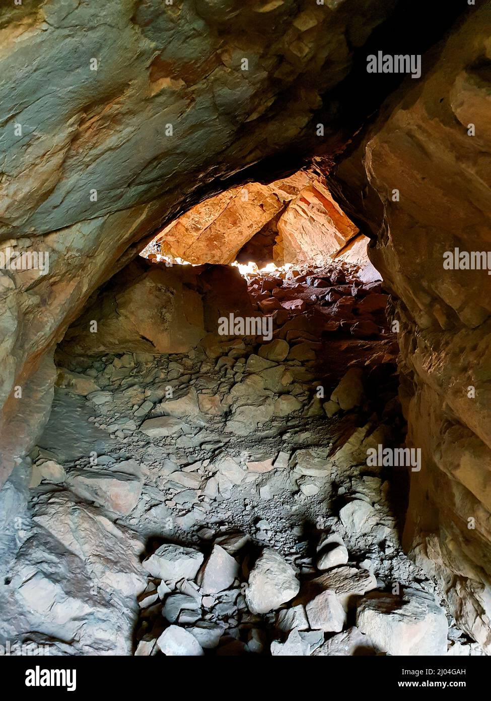 Kleiner natürlicher Tunnel im Fels mit Licht am Ende Stockfoto