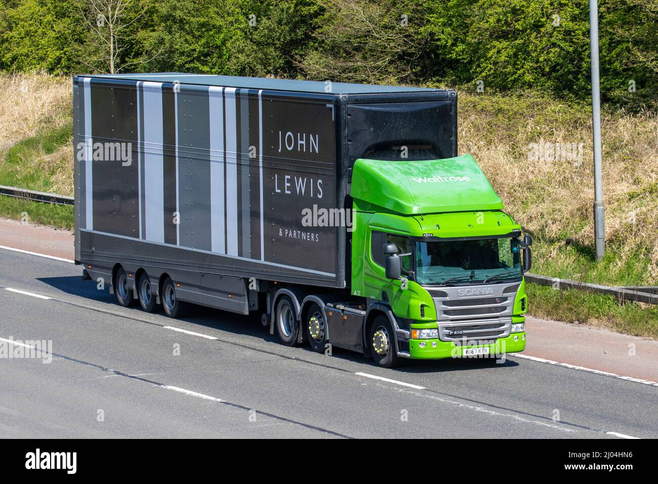 John Lewis & Partners Sattelanhänger mit Waitrose Green Scania P410 LKW-Zugmaschine auf der Autobahn M61 Manchester, Großbritannien Stockfoto