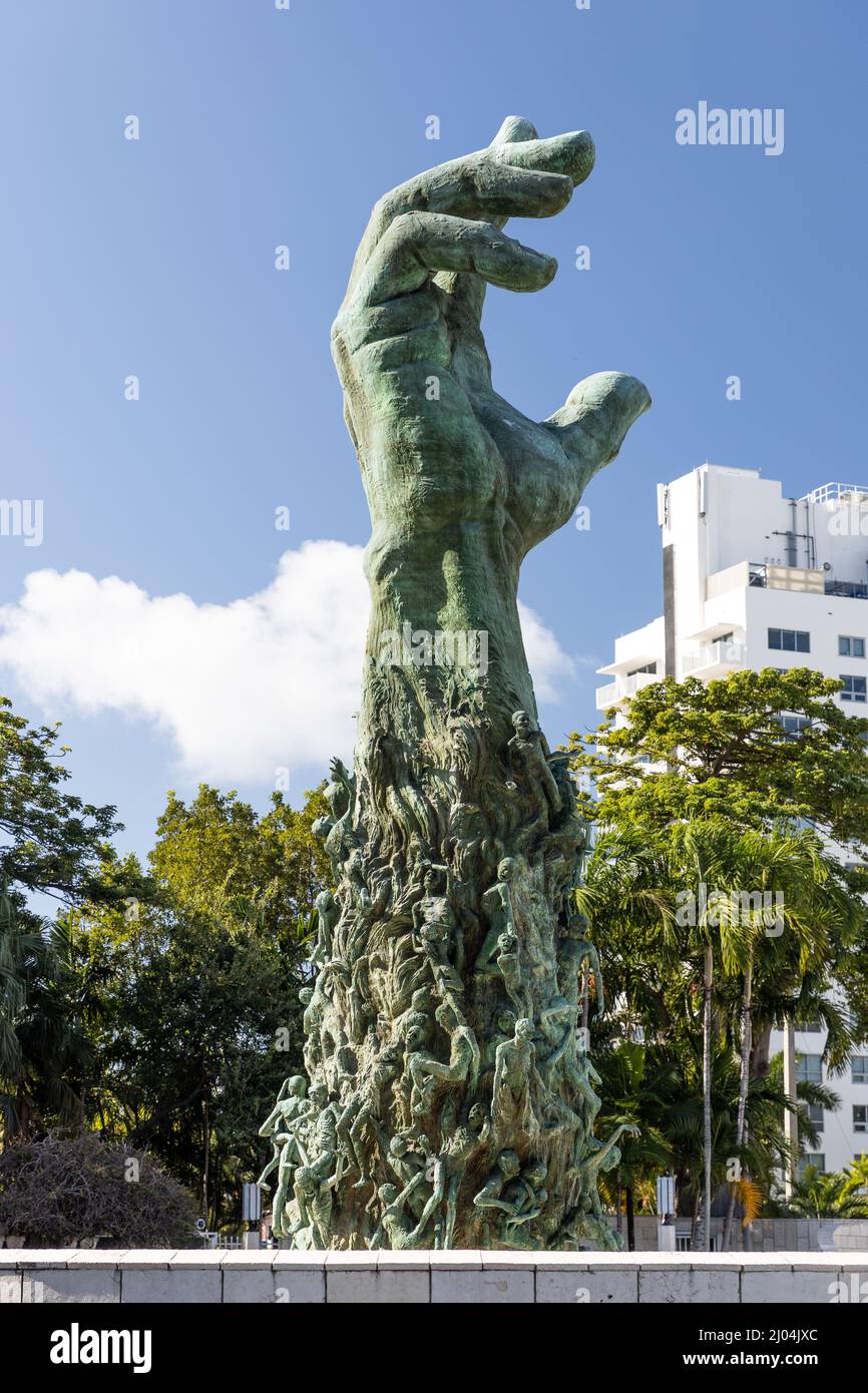 Das Holocaust Memorial in Miami Beach verfügt über einen Reflektionspool mit einer Hand, die nach oben reicht und Körper klettert, eine Gedenkmauer und eine Gedenkbrücke. Stockfoto