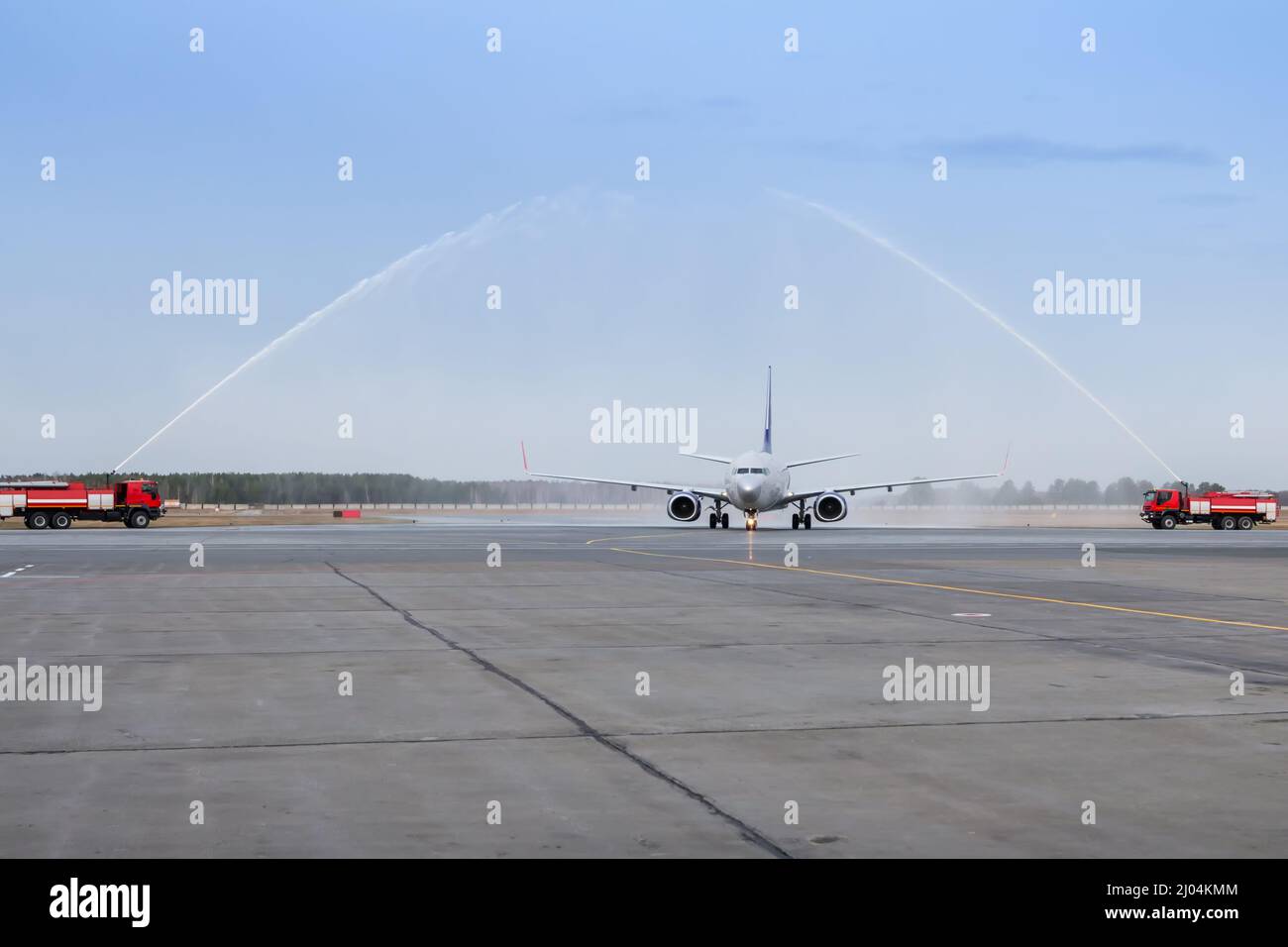 Wassergruß mit einem Feuerwehrauto am Flughafen für den ersten Besuch im Passagierflugzeug Stockfoto