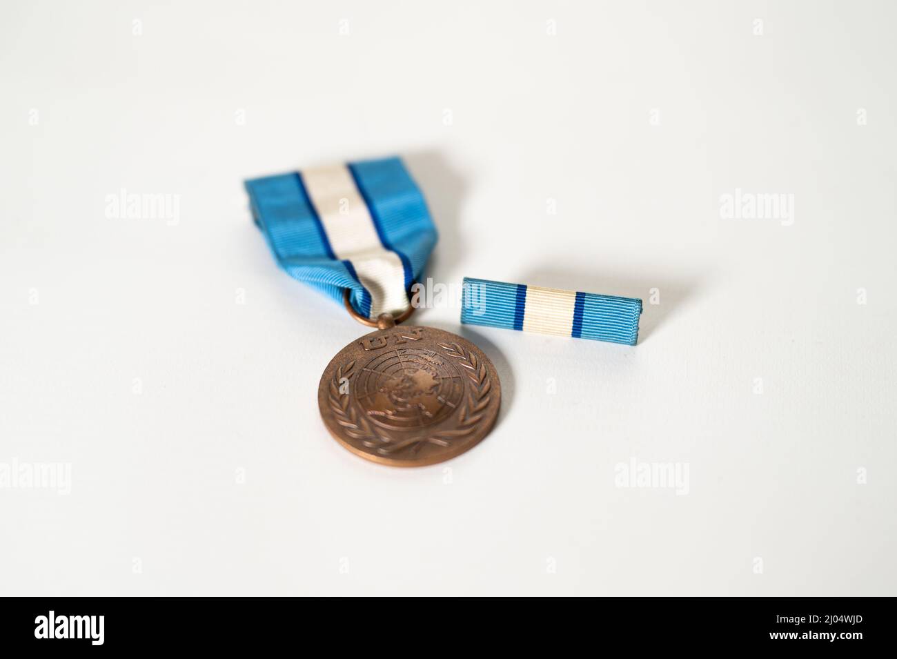 Flache Aufnahme der Vorderseite eines Friedensstifters der Vereinten Nationen mit Medaille und Dienstband auf weißem Hintergrund Stockfoto