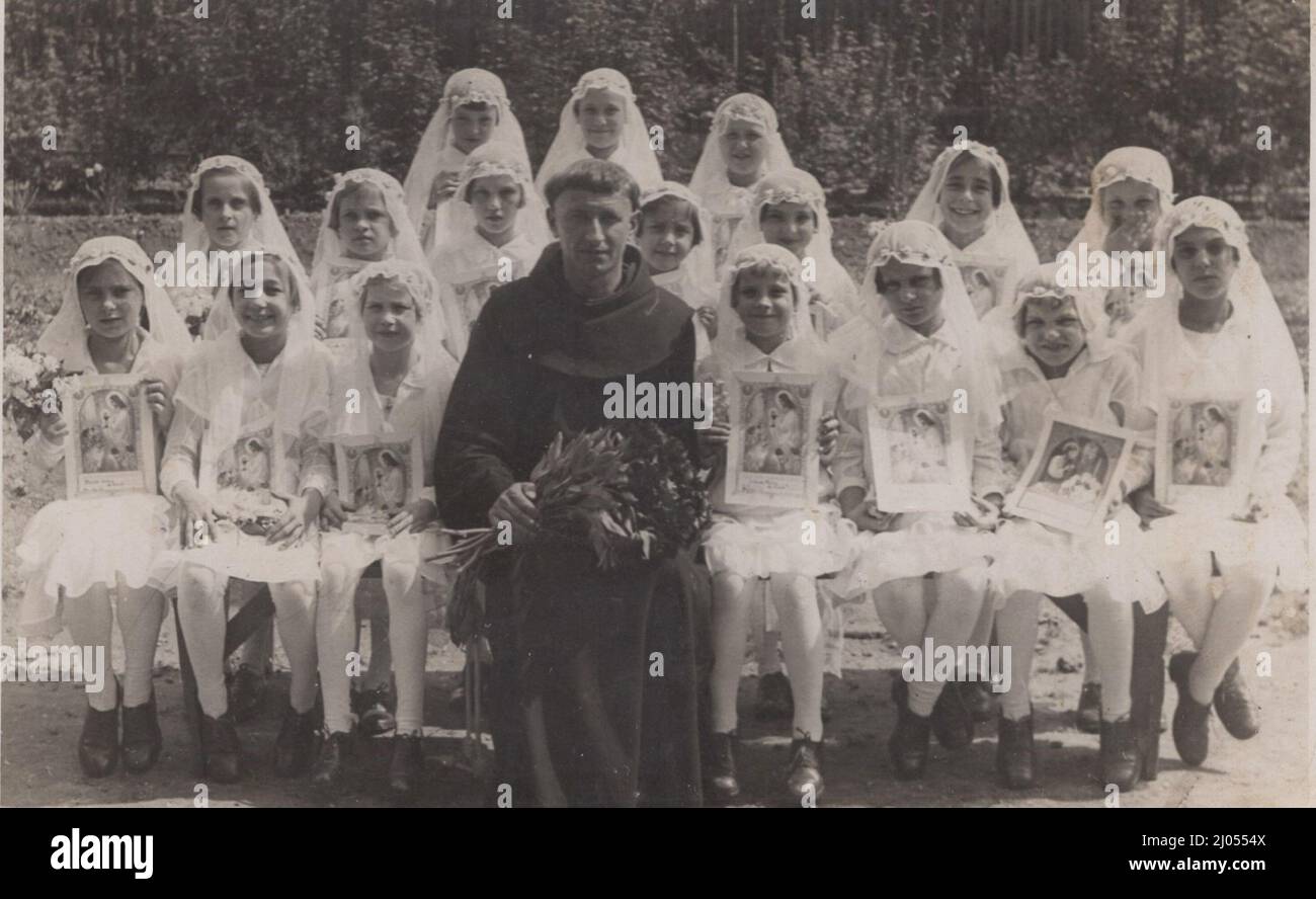 Original antiken 20. Jahrhundert Foto über eine Mädchenklasse kurz nach der ersten Kommunion mit ihnen Lehrer (Religionslehrer), der ein Franziskaner Mönch in ihnen üblichen Uniform und Frisur war. Zeitraum: 1900s Quelle: Originalfoto Stockfoto