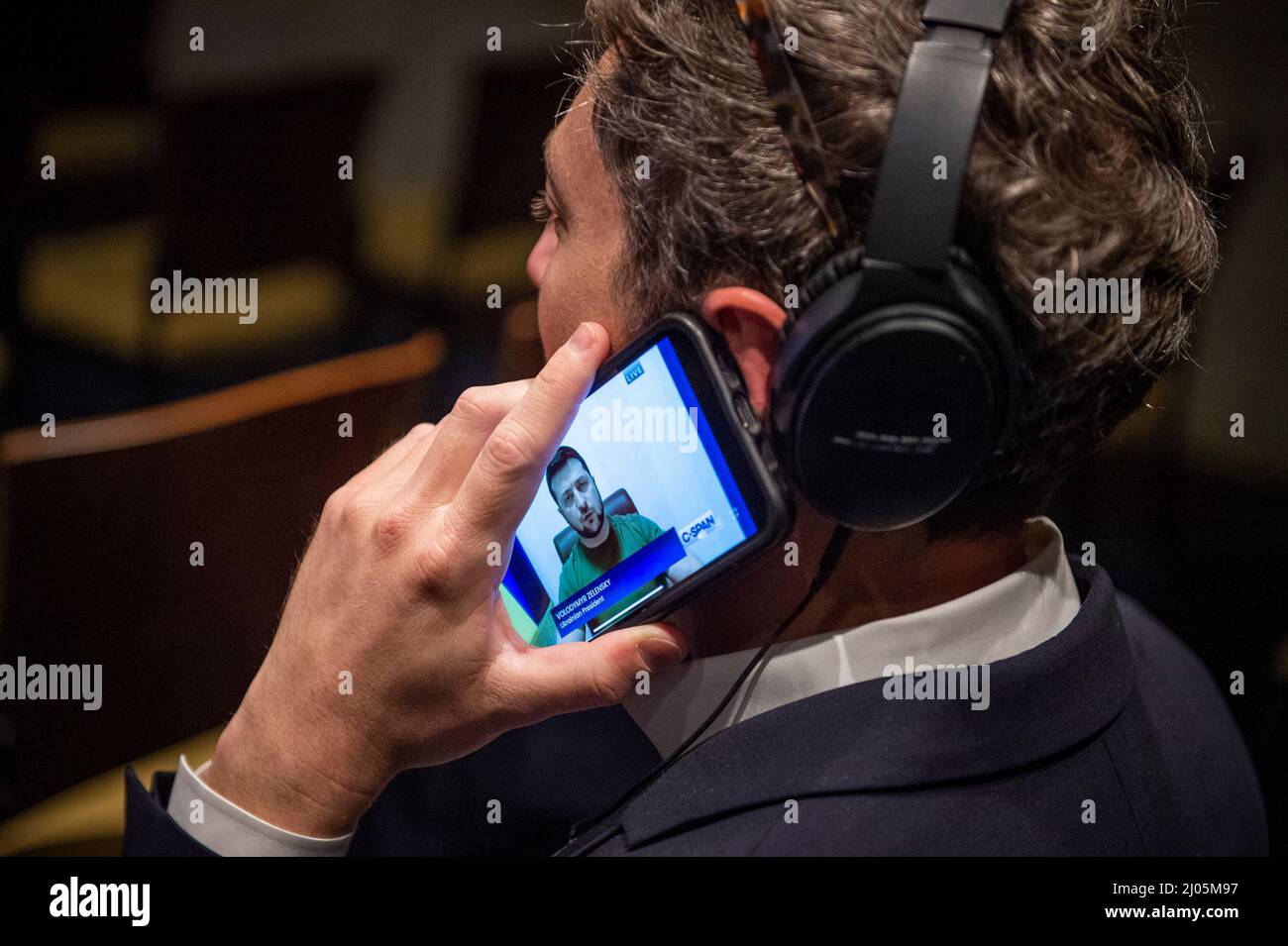 Ein Reporter hört sich am Mittwoch, den 16. März, eine virtuelle Rede des ukrainischen Präsidenten Wolodymyr Zelenskyy vor dem Kongress im US-Kapitol in Washington, DC, an. 2022. Die Adresse enthielt Grafiken und Videos des aktuellen Krieges in der Ukraine. Kredit: Rod Lampey/CNP Stockfoto