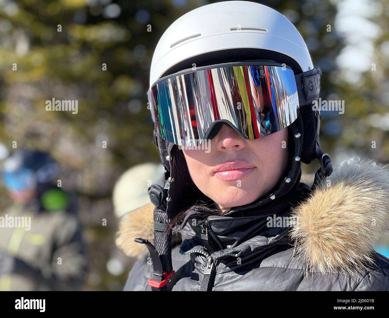 Porträt einer schönen jungen Frau, die im Skigebiet mit Skihelm und  Skibrille im Freien posiert Stockfotografie - Alamy