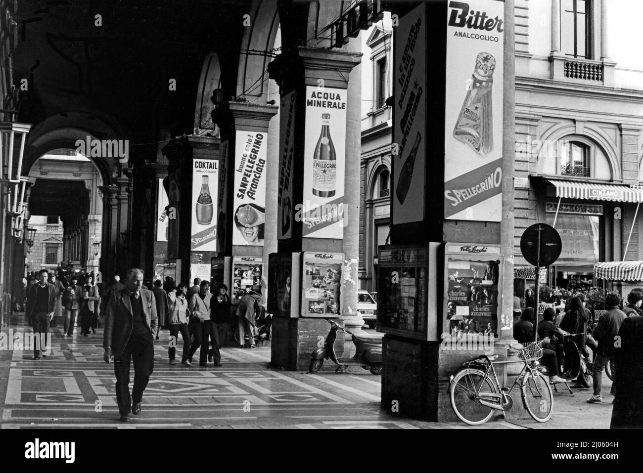 Straßenszene in Florenz, Italien mit Plakaten für San Pellegrino Getränke in der Arkade mit belebten Fußgängern. Stockfoto