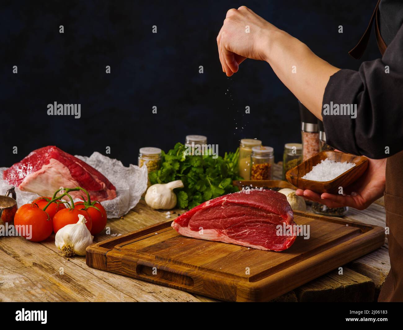 Kochen von Hackfleisch mit Rindfleisch und Schweinefleisch für Hamburger-Koteletts von den Händen des Küchenchefs auf schwarzem Hintergrund. Es ist ein leeres Leerzeichen zum Einfügen vorhanden. Rezepte für Res Stockfoto