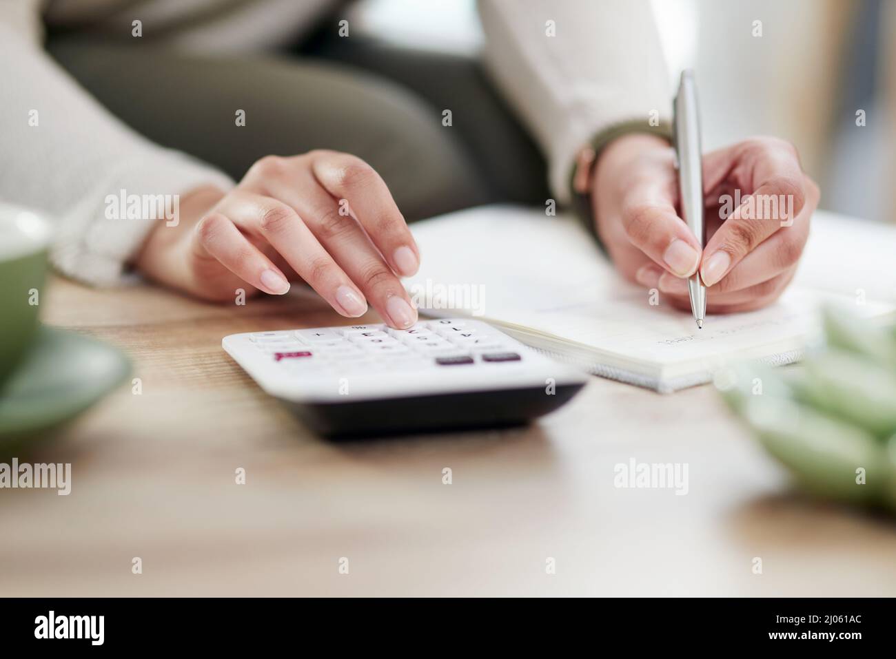 Einige Berechnungen durchführen, um sicherzustellen, dass die SHES finanziell auf Kurs sind. Nahaufnahme einer nicht erkennbaren Geschäftsfrau, die Notizen schreibt, während sie einen Rechner benutzt Stockfoto