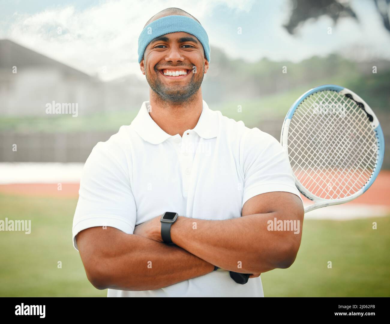 Bereit, etwas Konkurrenz zu machen. Ein beschnittenes Porträt eines hübschen jungen Tennisspielers, der draußen mit gefalteten Armen steht. Stockfoto