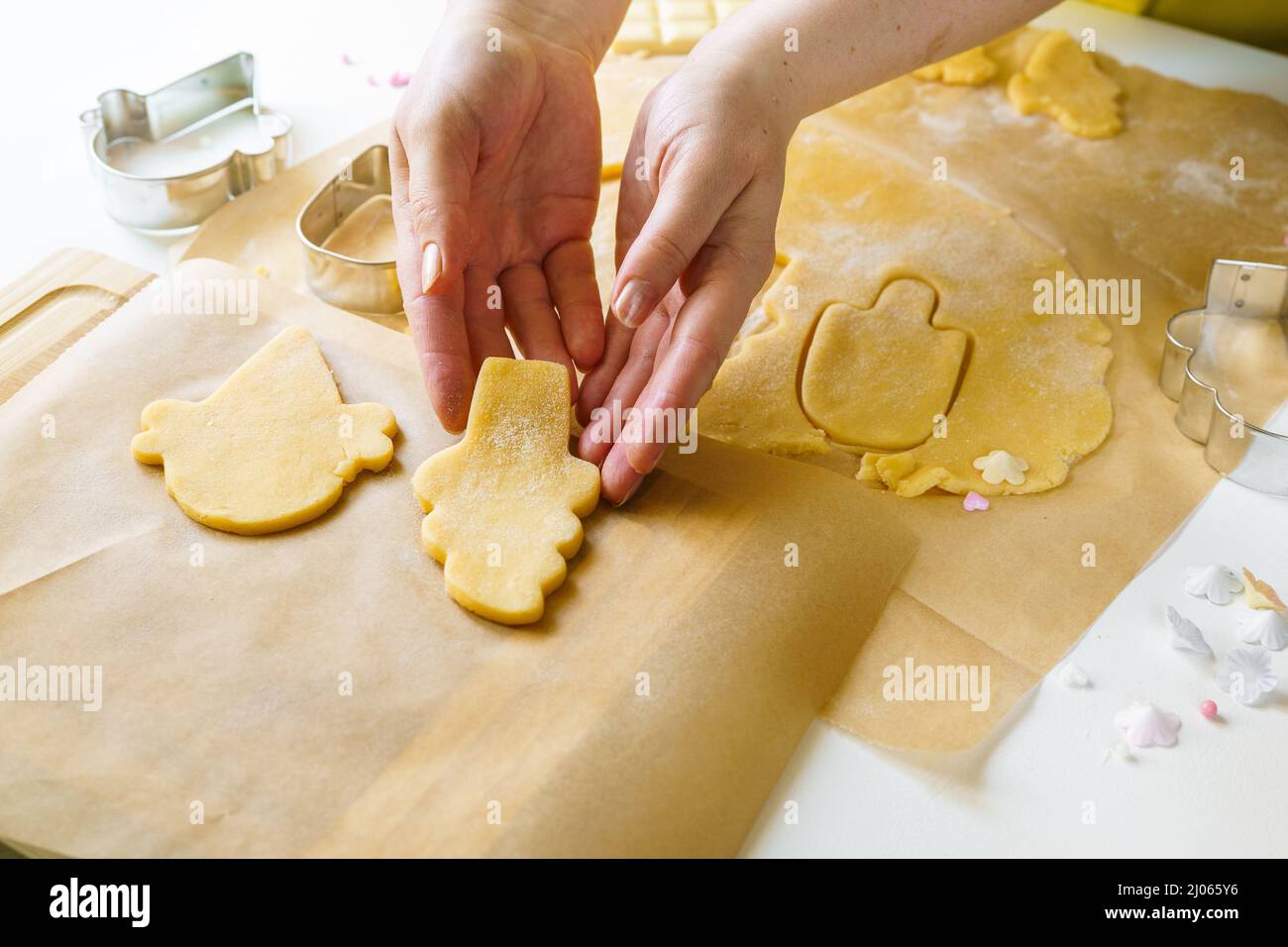 Weibliche Hände schneiden Teig in Lolly-Eis-Form, während Zucker Cookies. Nahaufnahme. Sommerkonzept. Heimunterhalt Stockfoto