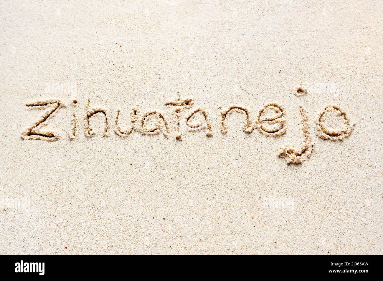 Handschriftliche Worte 'Zihuatanejo' auf Sand am Strand Stockfoto