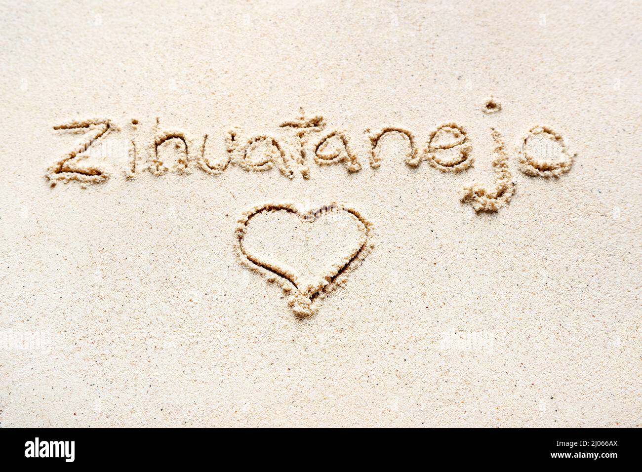 Handschriftliche Worte 'Zihuatanejo' auf Sand am Strand Stockfoto