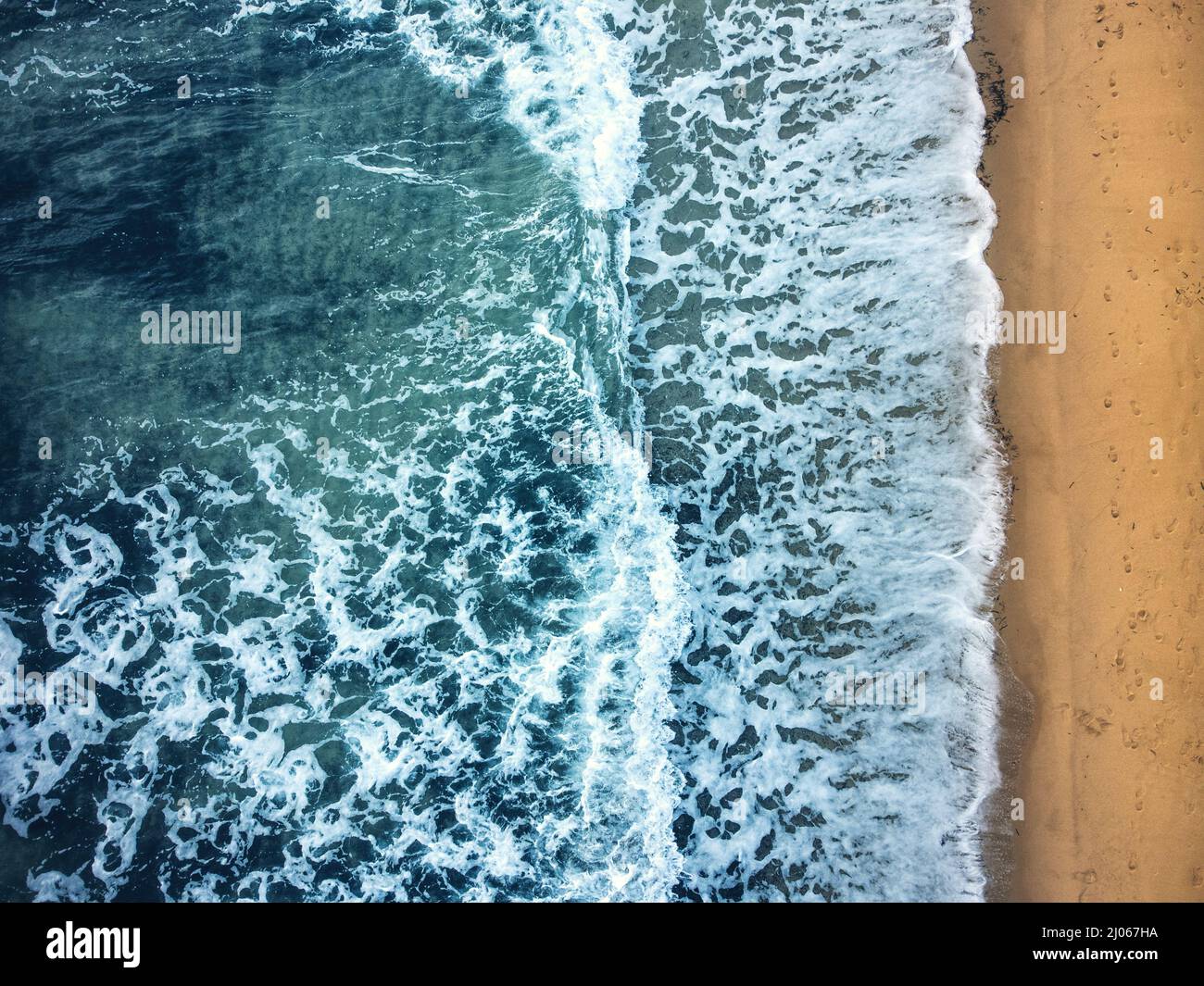 Luftaufnahme eines Strandes mit blauem Meer und gelbem Sand. Stockfoto