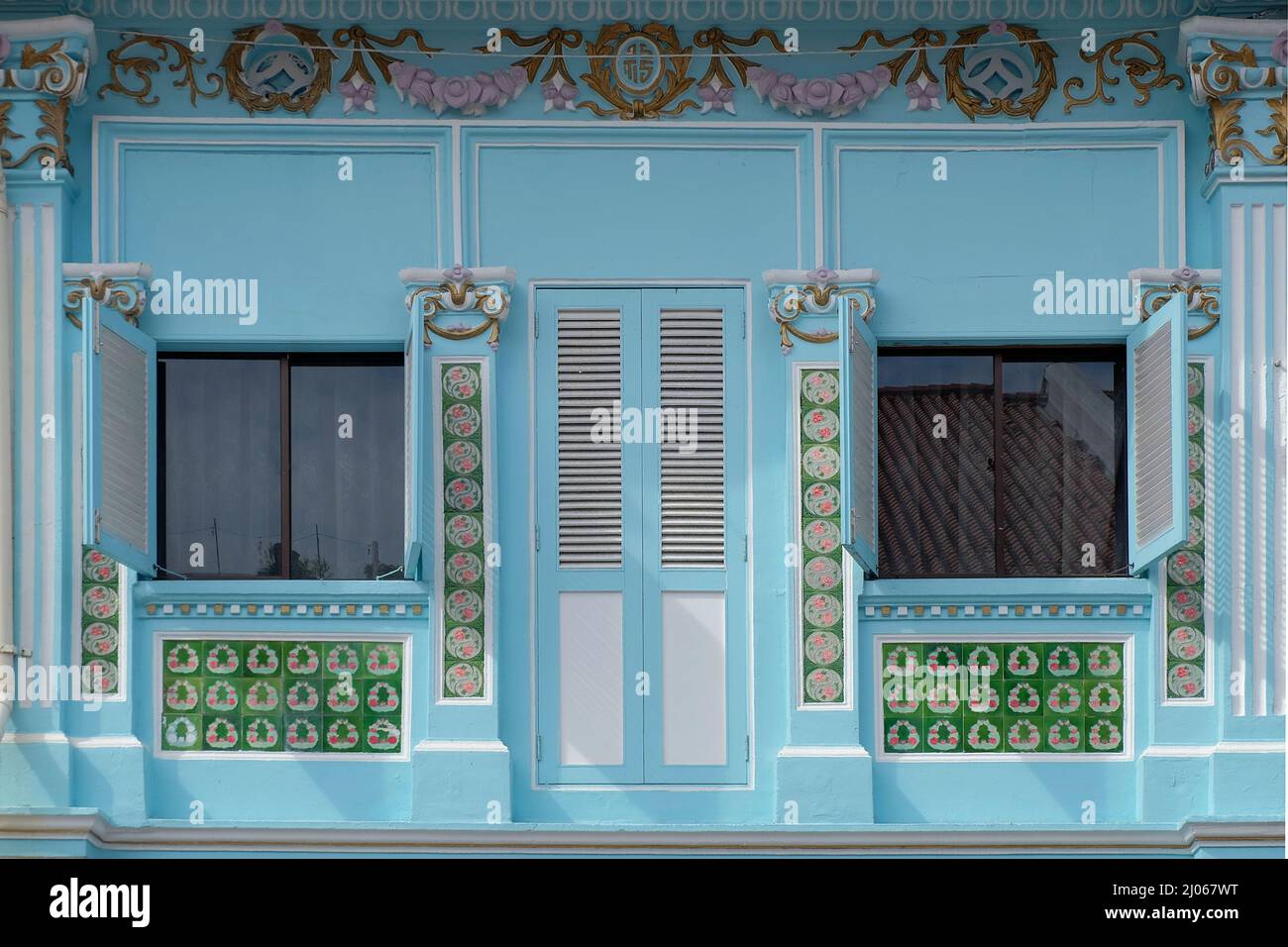 Straits Chinese Peranakan Shophouse exterior with wooden lovers, Rokoco Designs, floral Mosaic Tiles with Taiji & stilised Chinese Fortune Symbols Stockfoto