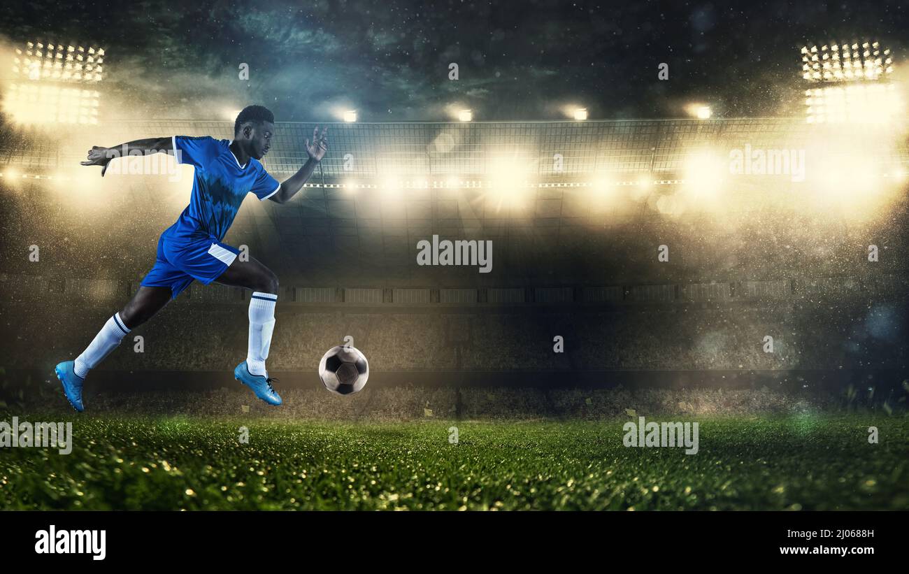 Fußballspieler in blauer Uniform sprintet schnell mit dem Ball im Stadion Stockfoto