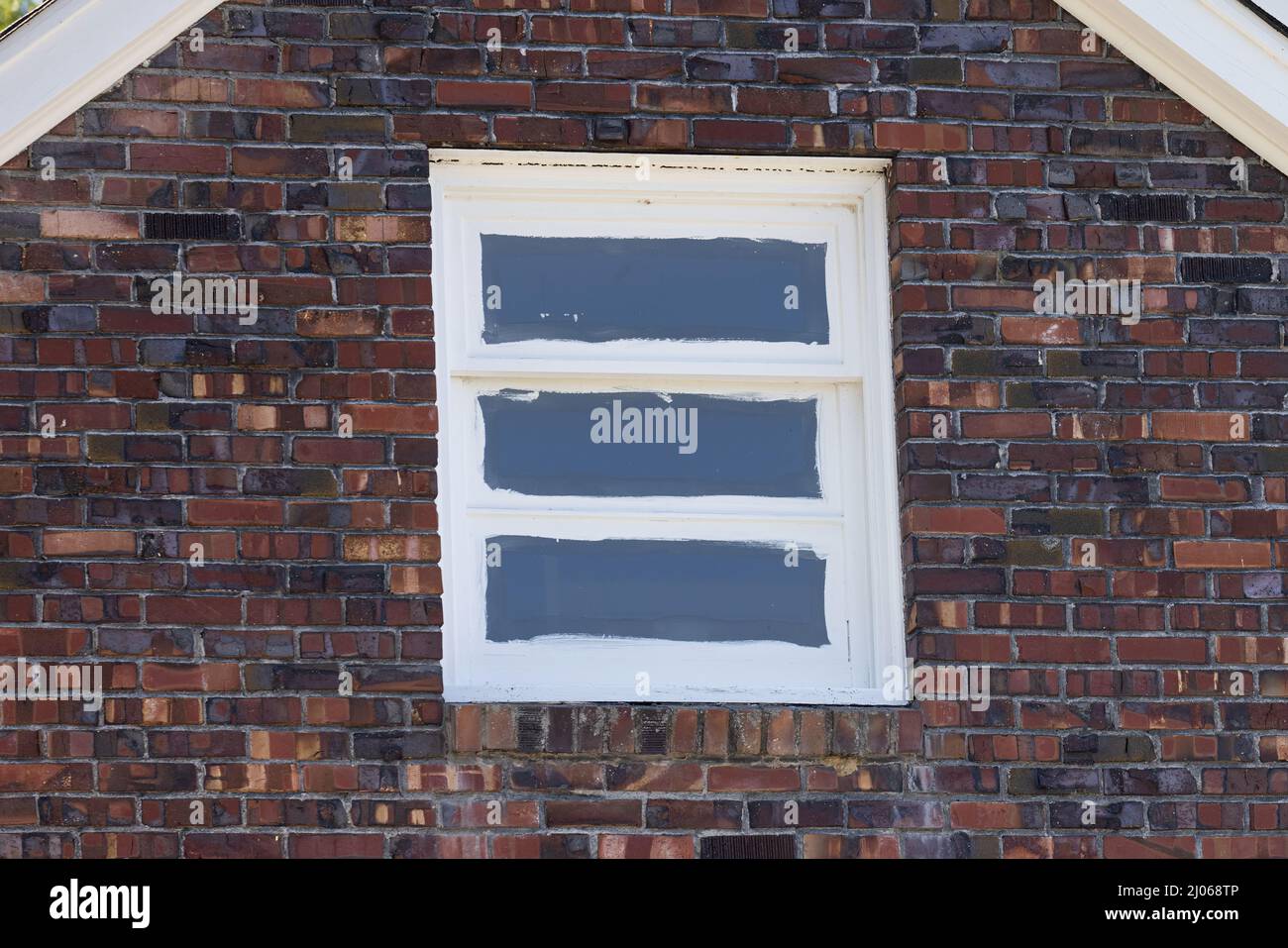 Weiß gestrichenes Fenster in einer Ziegelwand Stockfoto