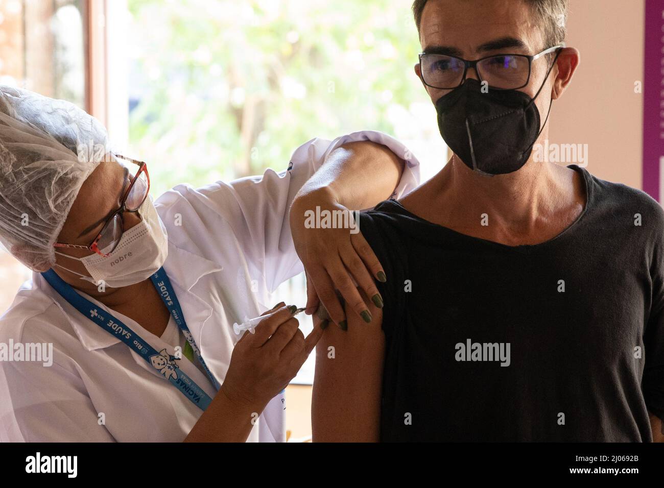 Rio De Janeiro, Brasilien. 16. März 2022. Ein Mann erhält am 16. März 2022 an einer Impfstelle in Rio de Janeiro, Brasilien, den Impfstoff COVID-19. Brasilien hat zwei Fälle von Infektionen mit der neuen Deltacron-Variante des Coronavirus bestätigt, das genetische Merkmale der Delta- und Omicron-Varianten kombiniert, sagte der brasilianische Gesundheitsminister Marcelo Queiroga am Dienstag. Quelle: Wang Tiancong/Xinhua/Alamy Live News Stockfoto