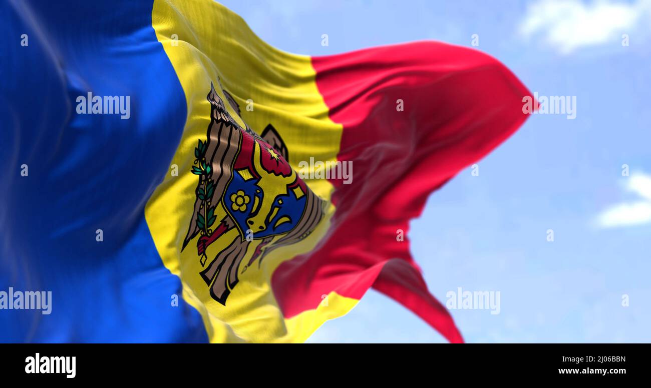 Detail der Nationalflagge der Republik Moldau, die an einem klaren Tag im Wind winkt. Moldawien ist ein souveräner Staat in Osteuropa. Selektiver Fokus. Stockfoto