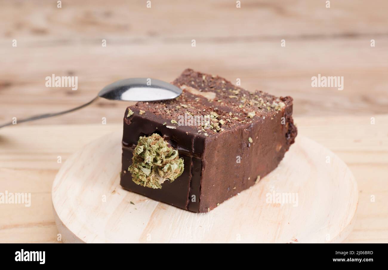 Schokoladen-Cupcake-Muffins mit Cannabisknospen. Marihuana Hanf medizinische Drogen in Lebensmitteln Dessert. Schokolade Kräuter Muffins Kochen. Marihuana-Kuchen auf einem braunen Stockfoto