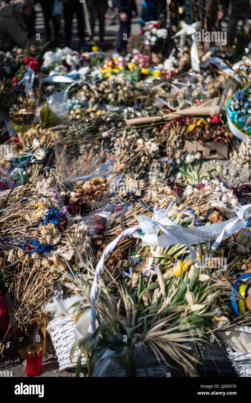 Lviv, Ukraine. 15. März 2022. Blumen von Trauernden, die gefallenen Soldaten Respekt zollen. Die Trauernden zollen den drei gefallenen Soldaten, die beim russischen Luftangriff auf den Militärstützpunkt Javoriv am 13. März 2022 getötet wurden, ihren letzten Respekt. Lokale Behörden berichteten, dass 35 Menschen auf dem Stützpunkt, der sich in der Nähe der westlichen Grenze der Ukraine zu Polen befindet, getötet und 134 verletzt wurden. (Foto: Laurel Chor/SOPA Images/Sipa USA) Quelle: SIPA USA/Alamy Live News Stockfoto