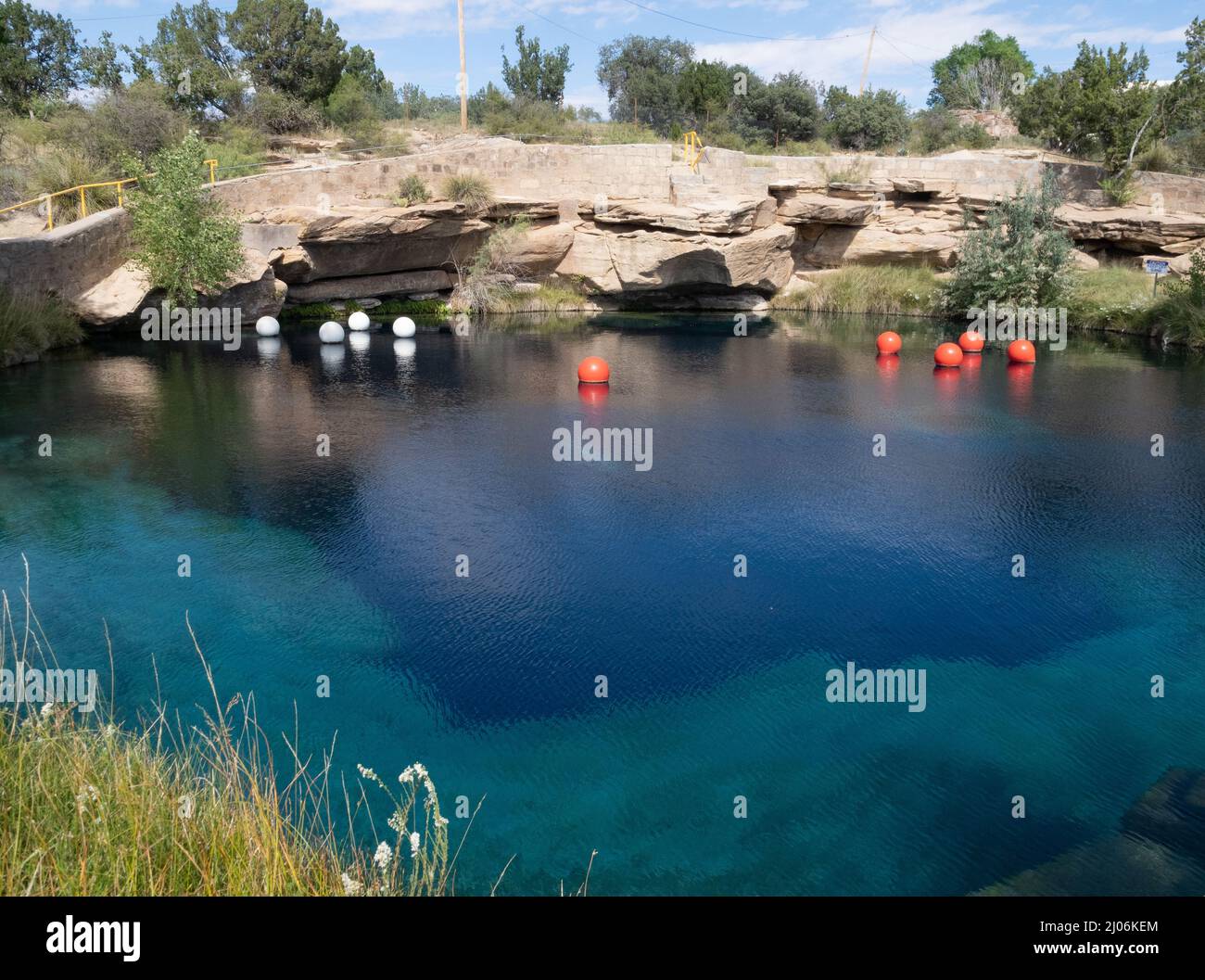 Park in Santa Rosa, New Mexico, mit dem Blauen Loch, das bei Schwimmern und Tauchern beliebt ist. Weiße und rote Tauchbojen befinden sich auf der Wasseroberfläche. Stockfoto
