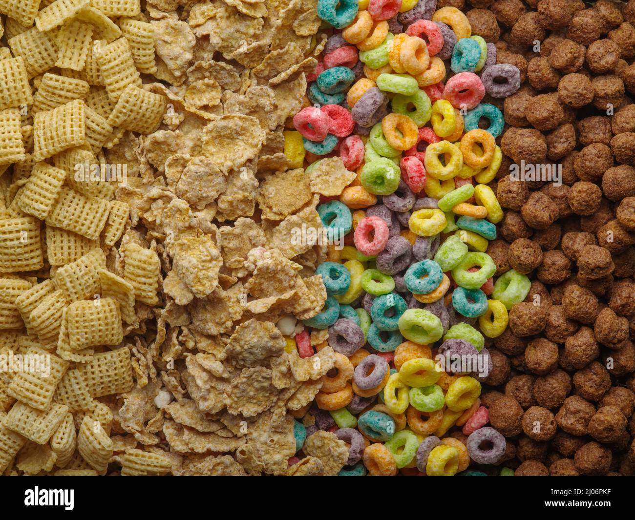 Verschiedene Vollkornfrühstücke - knusprige Pads, Müsli, fruchtige Maisringe und Schokoladenkugeln. Gesunde vegetarische und Babynahrung. Banner, Werbung. Stockfoto