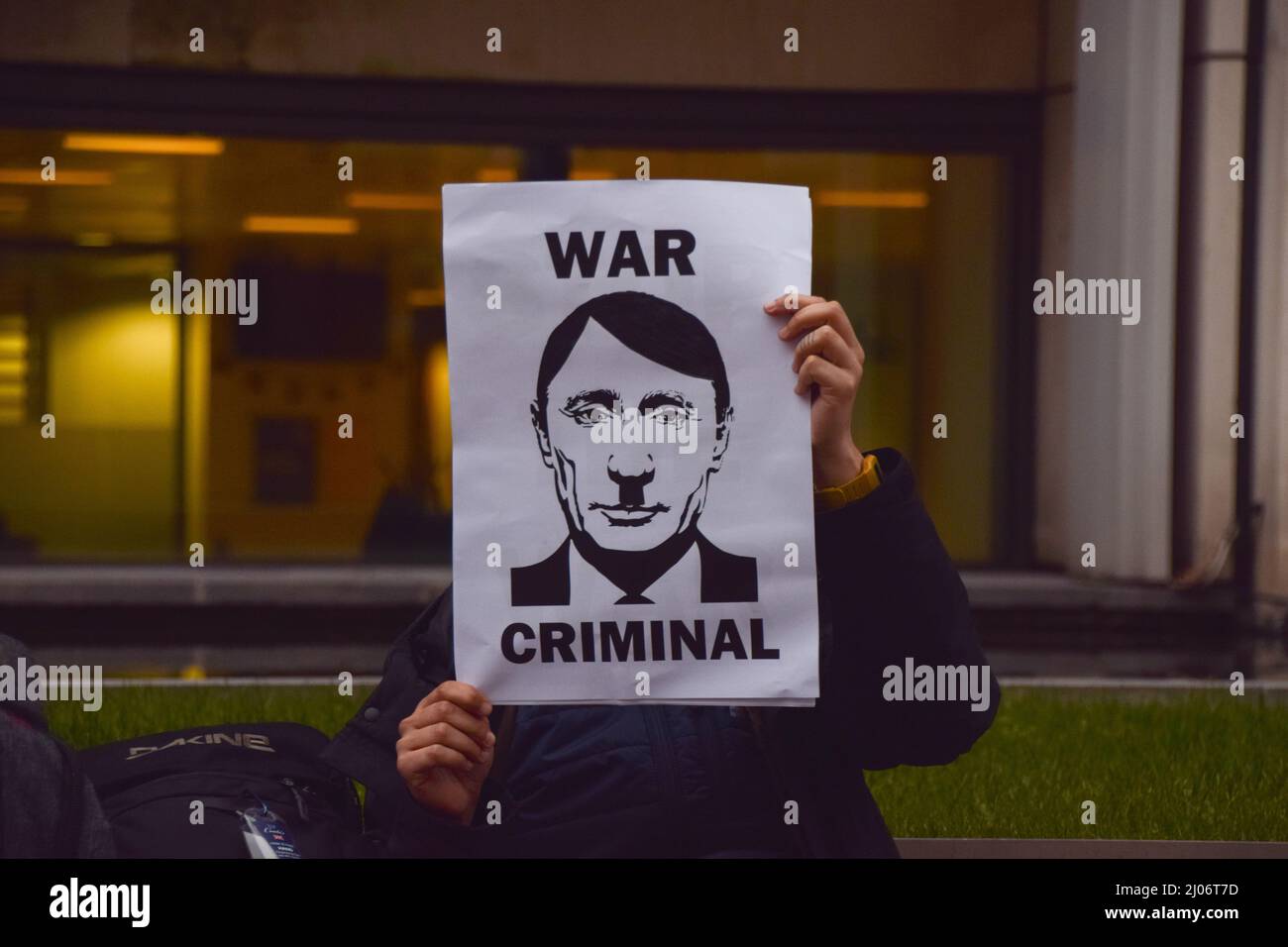 London, England, Großbritannien. 15. März 2022. Ein Protestler hält ein Zeichen, das Putin mit Hitler vergleicht und ihn als „Kriegsverbrecher“ bezeichnet. Demonstranten versammelten sich vor dem Innenministerium in Solidarität mit der Ukraine und forderten die britische Regierung auf, auf die Visumpflicht für ukrainische Flüchtlinge zu verzichten. (Bild: © Vuk Valcic/ZUMA Press Wire) Stockfoto