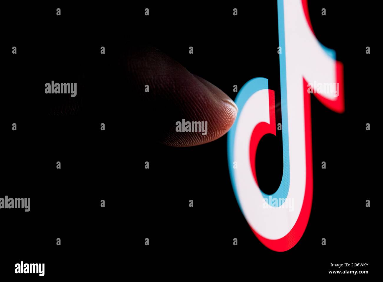 Der Finger greift auf dem Smartphone-Bildschirm nach dem Logo des sozialen Netzwerks TikTok. Stockfoto