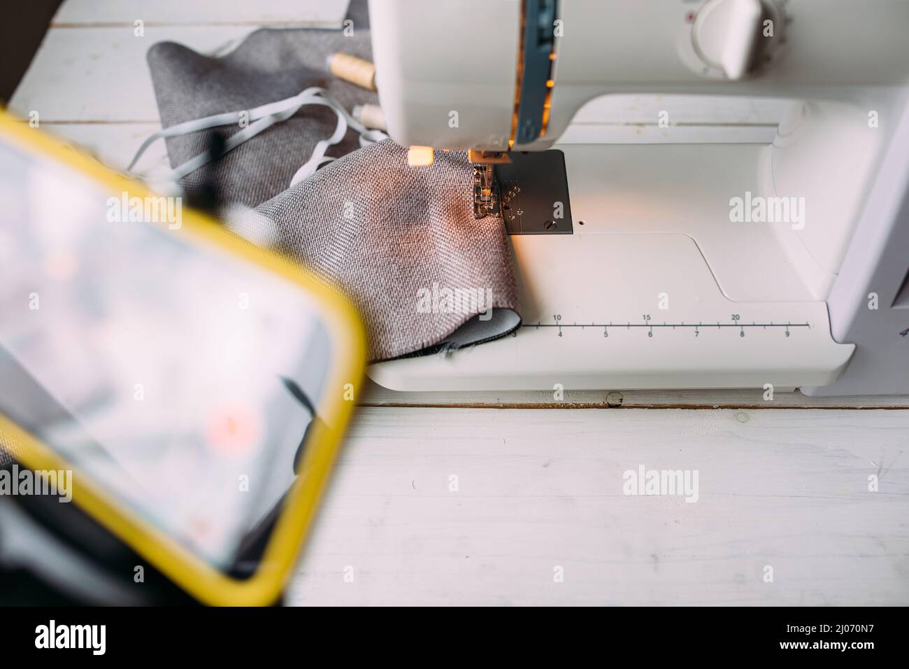 Drehvideo zum Nähprozess, Workshop zum Thema Bekleidungsdesign auf dem Smartphone Stockfoto