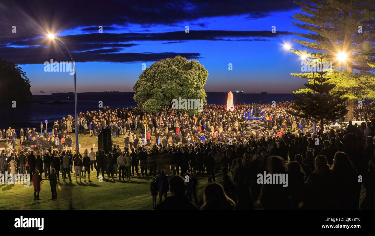 Ein Anzac Day-Morgendienst in Mount Maunganui, Neuseeland. Um den Mount Maunganui Cenotaph hat sich eine Menschenmenge versammelt Stockfoto
