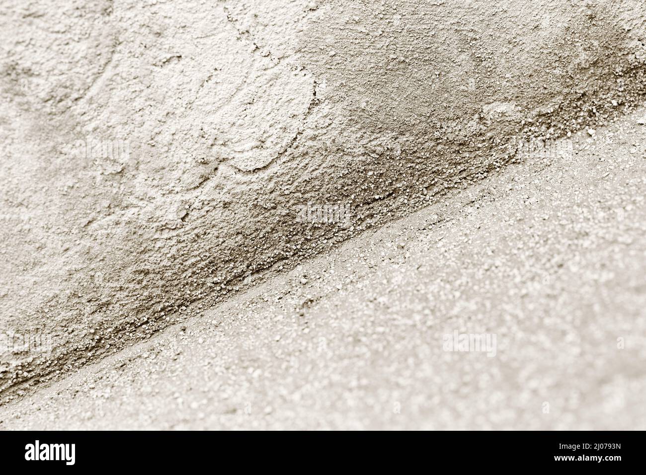 Nahaufnahme der inneren Ecke mit Kalk-Zement-Gipsmischung. Monochromatisches Bild mit selektivem Fokus. Hintergrundtextur der Bauindustrie. Stockfoto