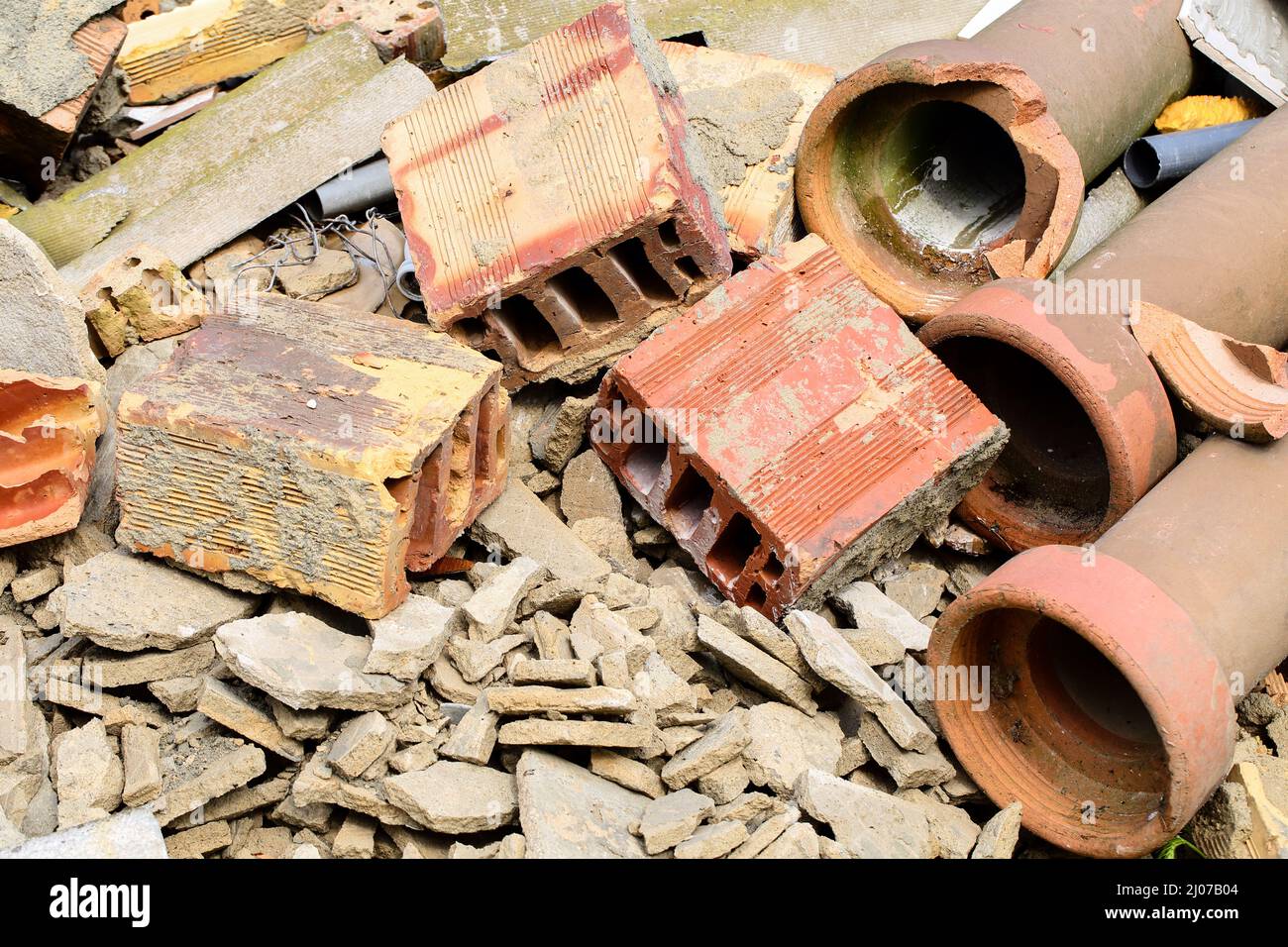 Nahaufnahme eines Stapels Bauabfall nach dem Abriss eines alten Gebäudes. Zerbrochene Ziegel, Zementstücke und Steinzeugwasserleitungen. Stockfoto