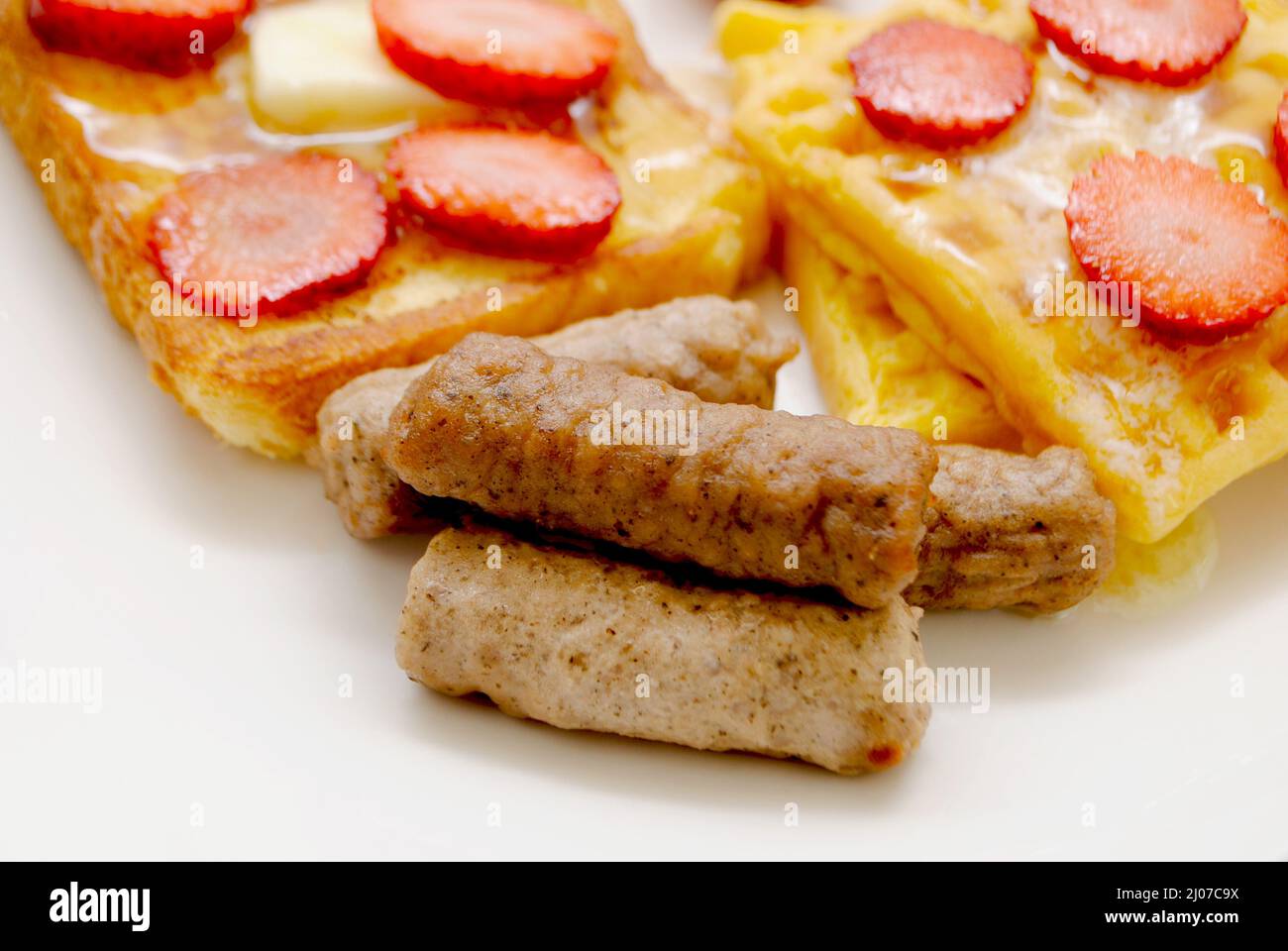 Nahaufnahme von gekochten Frühstückswurst Links, serviert auf einem Teller mit anderen Frühstücksspeisen Stockfoto
