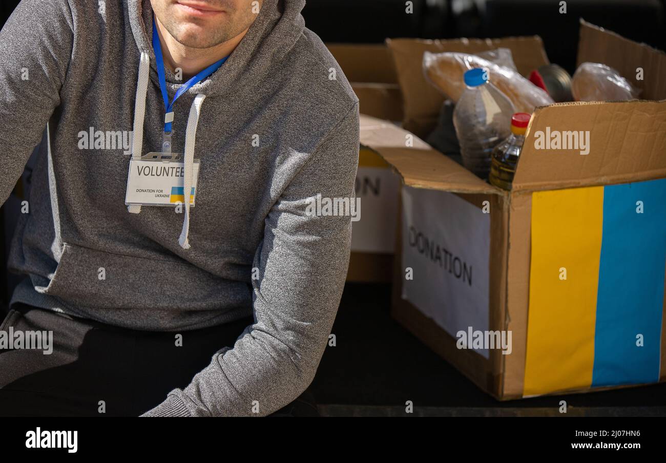 Cropped photo of a man volunteer taking a break from work with charity for ukranian refugees running away from the war. Stockfoto