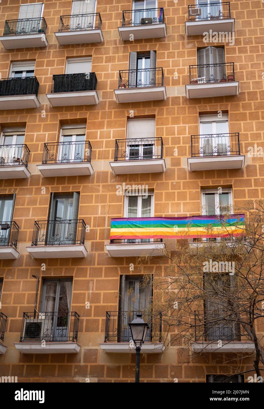 Fassade eines Gebäudes mit einer Gay-Pride-Flagge auf einem Balkon Stockfoto