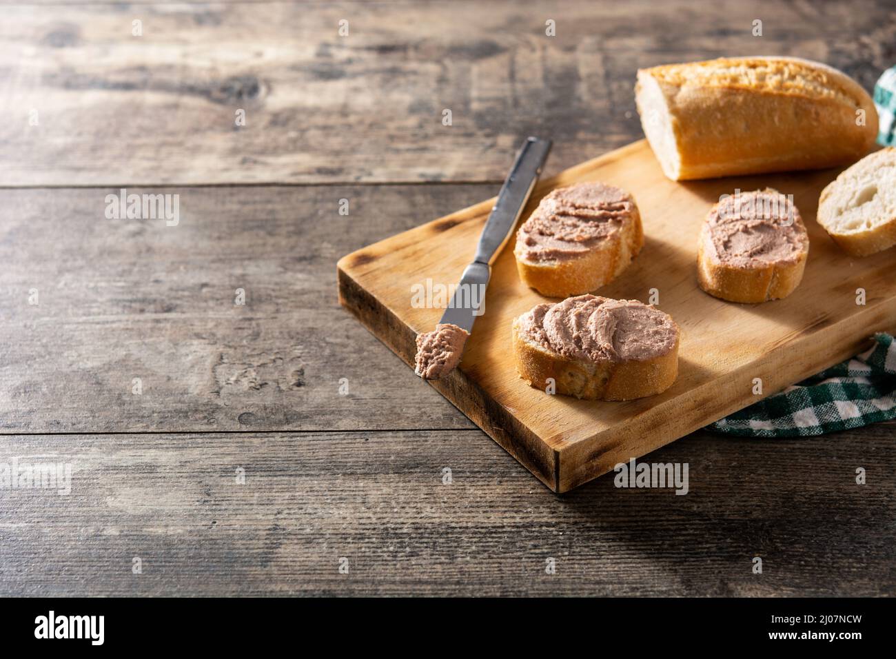 Geröstetes Brot mit Schweineleber-Pastete auf Holztisch Stockfoto