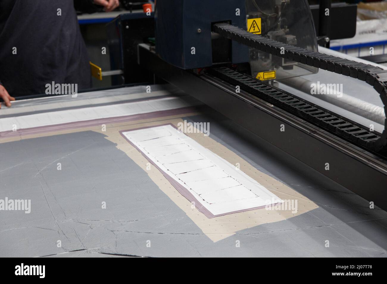 Industrielle Bekleidungsfabrik, ein spezielles Laser-Schneidemaster schneidet bestimmte textile Stücke aus. Konzept: Lasermaschine, Arbeit in einer Fabrik, Automatische Cu Stockfoto